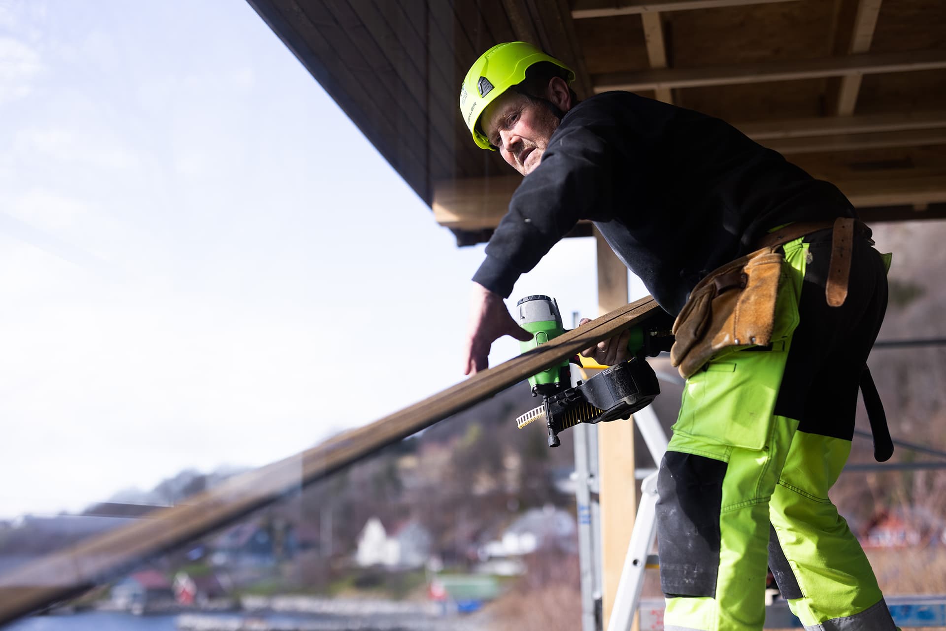 Tømrer arbeider med spikerpistol og treverk